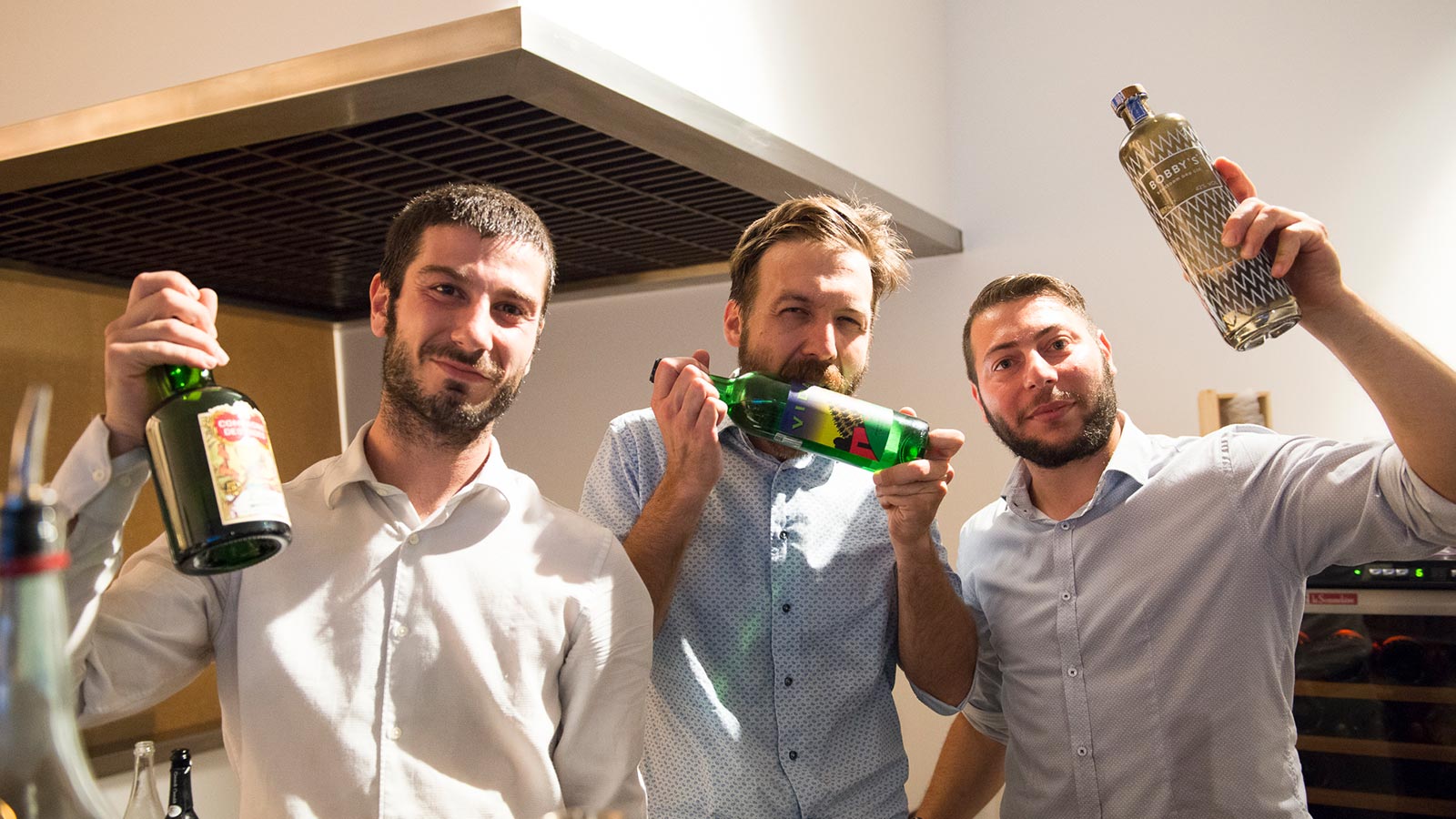 Una parte del team de La Bottega si diverte con le bottiglie di distillati